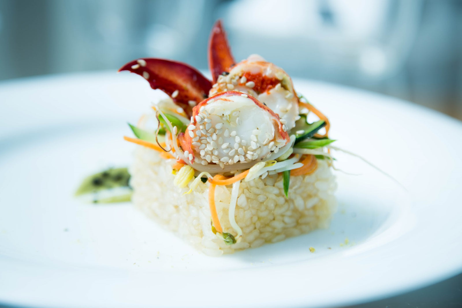 Risino saltato alla soia e zenzero e verdure servito con astice al sesamo